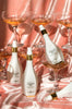 Several bottles of Champagne Spray amongst wide champagne glasses